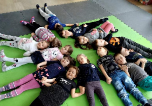 Dzieci leżąc na plecach tworzą wspólną sieć
