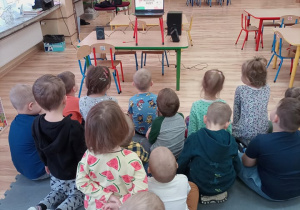 Przedszkolaki oglądają prezentację multimedialną.