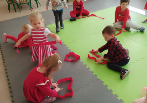 Dzieci układają serca z pasków bibuły