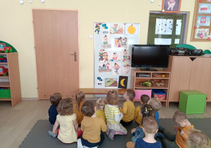Dzieci siedzą przed ilustracjami opowiadania