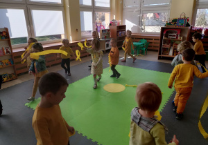 Dzieci tańczą z paskami żółtej bibuły