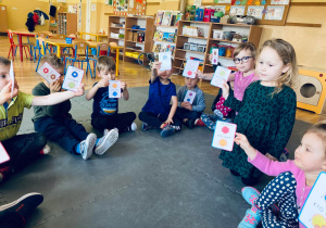 Pzedszkolaki na koniec zabawy pokazują swoje karty z pączkami.
