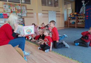 Dzieci słuchają czytanego przez nauczycielkę opowiadania "Życzliwość popłaca".