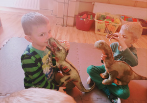 Chłopcy bawią się dinozaurami, które przynieśli do przedszkola.