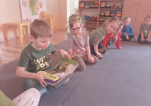 Wiktorek pokazuje książki o dinozaurach, które przyniósł do przedszkola.