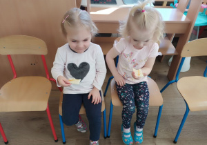 Dziewczynki jedzą wafelek z miodem