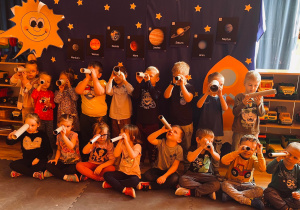 Przedszkolaki wypatrują gwiazd przez lunety.