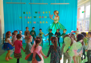 Dzieci tańczą w kole i śpiewają piosenkę na powitanie wiosny