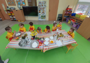 Dzieci siedzą przy wspólnym stole