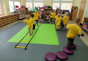 Dzieci wykonują ćwiczenia na przyrządach gimnastycznych