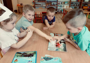 Dzieci sklejają książkę.