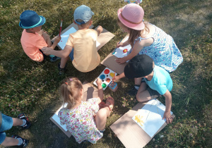 Dzieci malują farbami.