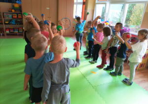 Przedszkolaki stoją w dwóch rzędach trzymając kolorowe piłeczki.