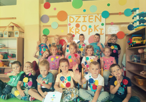 Grupowe zdjęcie przedszkolaków pod napisem Dzień Kropki.