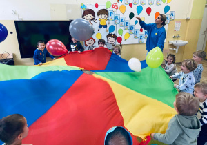 Radosne dzieci odbijają balony.