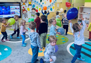 Dzieci bawią się balonami przy piosence.