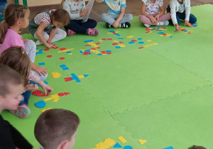 Dzieci układają figury geometryczne według instrukcji