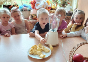 Dzieci wkładają Jabłka do szklanego naczynia