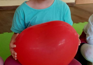 Dziewczynka trzyma w dłoni balon