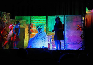 Na scenie zasiada aktor w kostiumie sowy