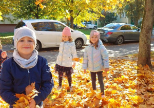 Dzieci bawią się jesiennymi listkami