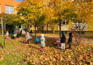Przedszkolaki bawią się w ogrodzie.