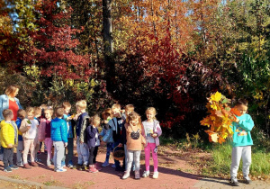 Dzieci wracają do przedszkola z zebranymi darami lasu