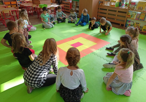 Dzieci siedzące wokół planszy podczas gry "Kartofelek".