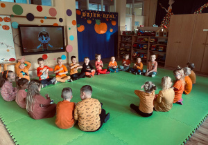 Przedszkolaki siedzą w kółeczku podczas zabawy.