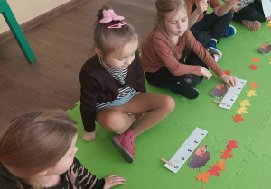 Dzieci zaznaczają klamrą cyfrę, która odpowiada ilości przeliczanych elementów