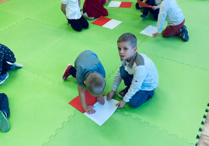 Dzieci w parach tworzą flagi podczas zabawy ruchowej.