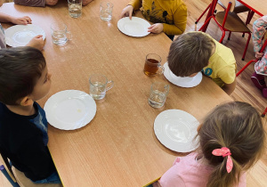 Dzieci zlizują miodek z talerzy.