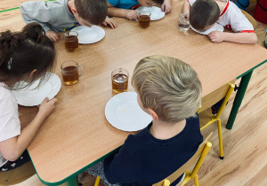 Dzieci zlizują miodek z talerzy.