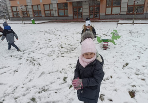 Dziewczynki na zaśnieżonym placu zabaw.