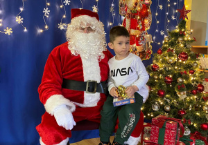 Chłopiec pozuje do zdjęcia z Mikołajem