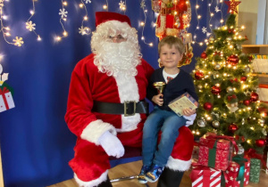 Dziecko pozuje do zdjęcia z Mikołajem