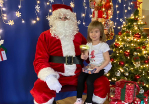 Dziewczynka pozuje do zdjęcia z Mikołajem