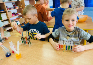 Przedszkolaki mieszają kolory w próbówkach.