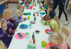 Dzieci siedzą przy stole i tworzą mydła