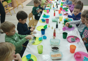 Dzieci siedzą przy stole i tworzą mydła