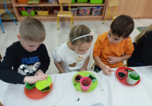 Dzieci wlewają ciepłą zabarwioną glicerynę do foremek.