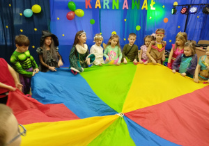 Dzieci podczas zabawy "A-ja-jaj" z chustą animacyjną.