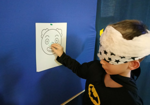 Chłopiec z zawiązanymi oczami w konkursie "Doklej nos klowna".