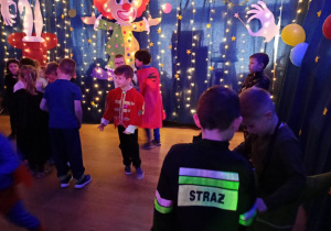 Dzieci w kolorowych przebraniach podczas zabawy.