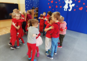 Przedszkolaki ubrane na czerwono podczas zabawy ruchowej.