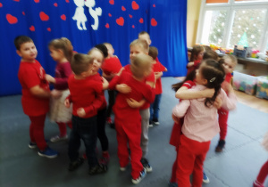 Przedszkolaki ubrane na czerwono podczas zabawy ruchowej.