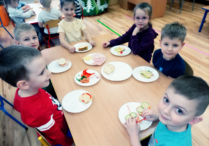Przedszkolaki przygotowują kanapeczki na podwieczorek.
