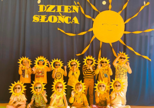Dzieci - słoneczka pozują na tle dekoracji.