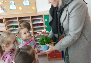 Dziewczynki wręczają kwiatka w podziękowaniu za wizytę