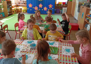Dzieci przy stolikach podczas malowania farbami rosnącymi